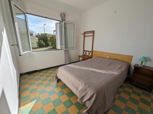 une chambre avec un lit et une grande fenêtre dans l'établissement Agréable T2, 4 pers, plain-pied ouvert sur terrasse, jardin clos, parking privé, proche plage et commerces - FR-1-797-24, à Port-la-Nouvelle