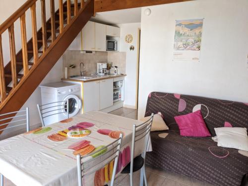 Il dispose d'une cuisine et d'un salon avec une table et un canapé. dans l'établissement Charmante Maison T2 Mezzanine avec Jardin et Parking, à 500m de la Plage - 6 Pers. - FR-1-797-46, à Port-la-Nouvelle