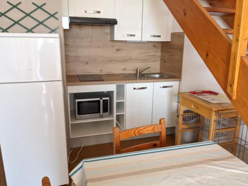 une petite cuisine avec un évier et un réfrigérateur dans l'établissement T2 Mezzanine à 250m de la plage pour 4/5 pers avec Parking et TV - FR-1-797-31, à Port-la-Nouvelle