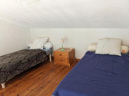 une chambre avec deux lits et une table avec une lampe dans l'établissement T2 Mezzanine à 250m de la plage pour 4/5 pers avec Parking et TV - FR-1-797-31, à Port-la-Nouvelle