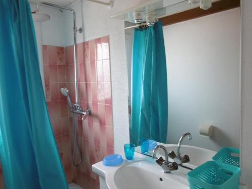La salle de bains est pourvue d'un lavabo et d'une douche avec rideau de douche. dans l'établissement T2 Mezzanine à 250m de la plage pour 4/5 pers avec Parking et TV - FR-1-797-31, à Port-la-Nouvelle