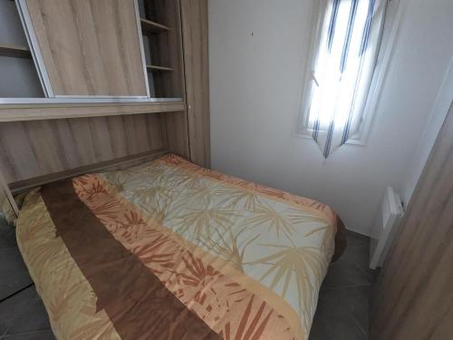 un petit lit dans une chambre avec une fenêtre dans l'établissement Grand T2 Climatisé 36m² avec Parking à 450m de la Plage - 4 Pers - FR-1-797-34, à Port-la-Nouvelle