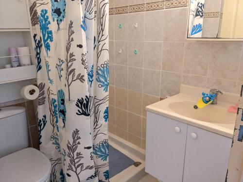 une salle de bain avec un rideau de douche et un lavabo dans l'établissement Villa T2 Mezzanine Climatisée avec Cour - 6 Pers - Parking - Proche Plage - Meublé Tourisme 1* - FR-1-797-44, à Port-la-Nouvelle
