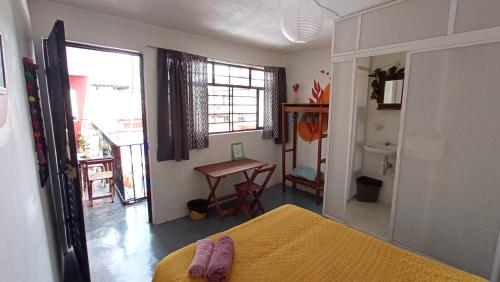 a bedroom with a bed and a table and a desk at Casa Huipil in San Cristóbal de Las Casas