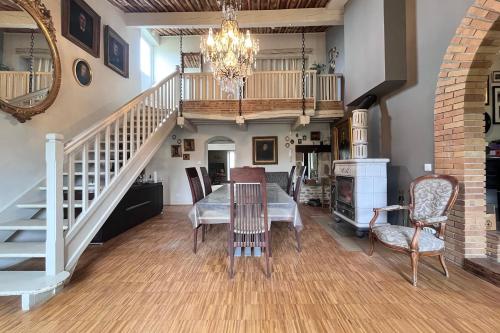 une salle à manger avec une table et des chaises et un escalier dans l'établissement Casa Ibor - Montchenu, à Montchenu
