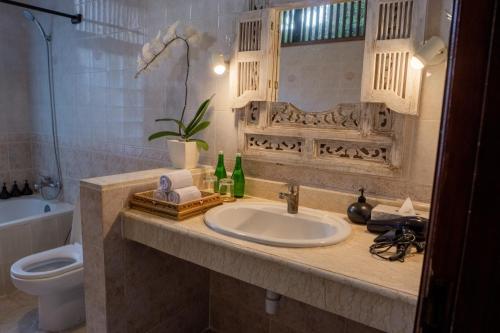 a bathroom with a sink and a toilet at Atres Griya Villa 5 Private Bedroom Kuta in Kuta