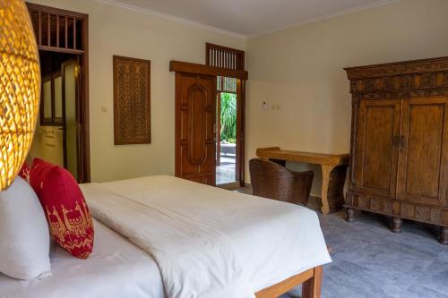 a bedroom with a bed and a wooden cabinet at Atres Griya Villa 5 Private Bedroom Kuta in Kuta