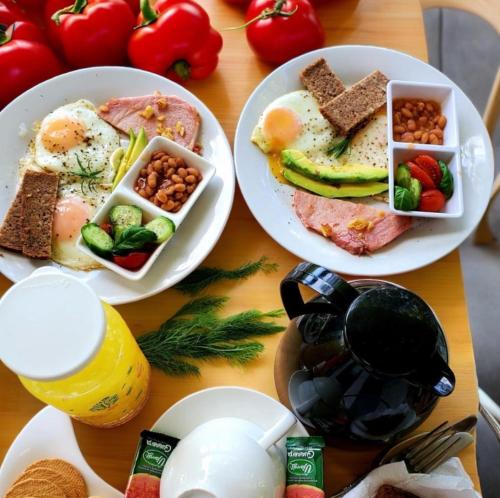 a table with plates of breakfast food on it at Villa La Fortuna Altos del Maria in Filipina