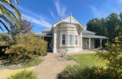 a white house with a porch and a yard at Tanunda House - Luxury 5 BR in Barossa Wine Region in Tanunda