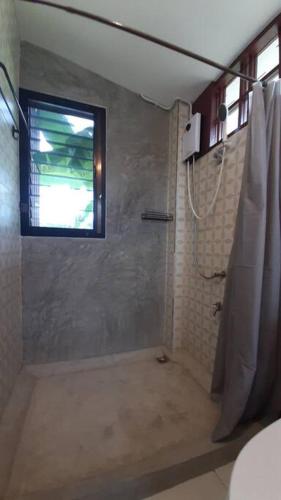 a bathroom with a shower and a window at Naam and Nork Vegetarian Farmstay in Ban Rong Wua (2)