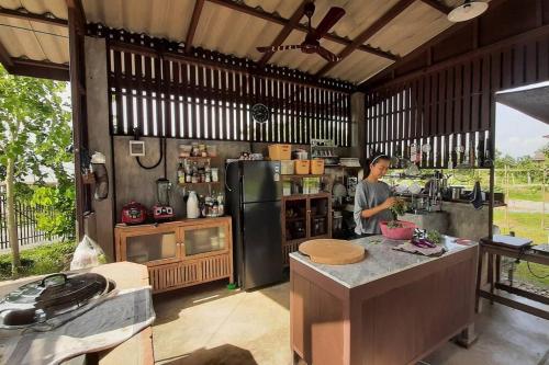 a man standing in a kitchen in a house at Naam and Nork Vegetarian Farmstay in Ban Rong Wua (2)