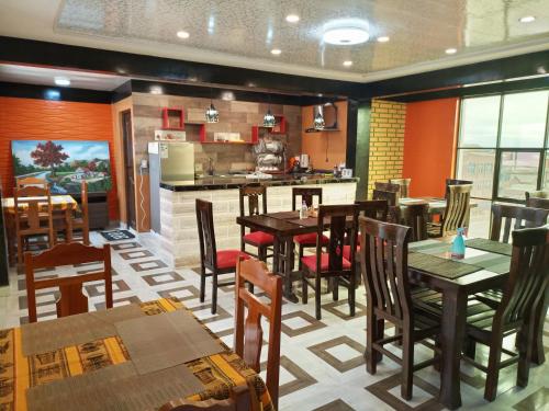 a restaurant with tables and chairs and a kitchen at Hotel Salty House in Uyuni
