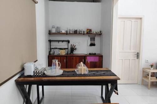 a wooden table in a room with a kitchen at Rumah Akbar Villa Taliwang in Labuanbalat