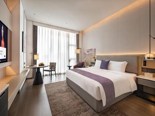 a hotel room with a bed and a desk at Grand Mercure Shenzhen Guangming in Shenzhen