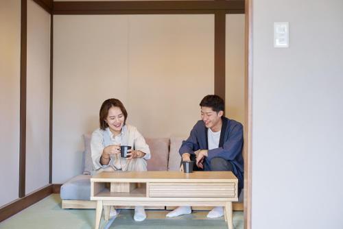 a man and woman sitting around a coffee table at The ONE -fujiyoshida- in Fujiyoshida