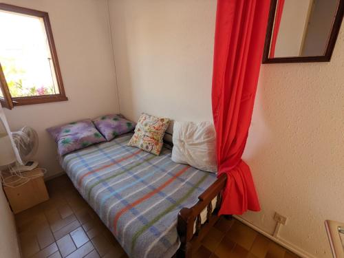 - un petit lit dans une chambre dotée d'un rideau rouge dans l'établissement Villa T3 Mezzanine Climatisée, Proche Plage, Parking et Terrasse - 6 Pers - FR-1-797-56, à Port-la-Nouvelle