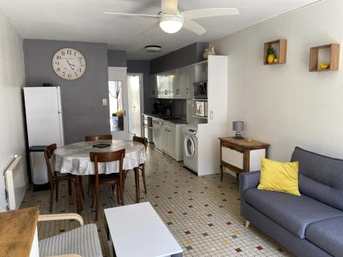 un salon avec un canapé bleu et une table dans l'établissement Villa T2 cosy, 40m², 4 pers, proche plage, 2 terrasses, tout équipé, calme et commerces à proximité - FR-1-797-53, à Port-la-Nouvelle