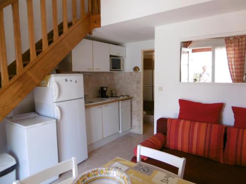 une cuisine et un salon avec un canapé et une table dans l'établissement Maison T3 cosy avec terrasse et parking, proche plage - 6 pers, entièrement équipée, secteur calme - FR-1-797-54, à Port-la-Nouvelle