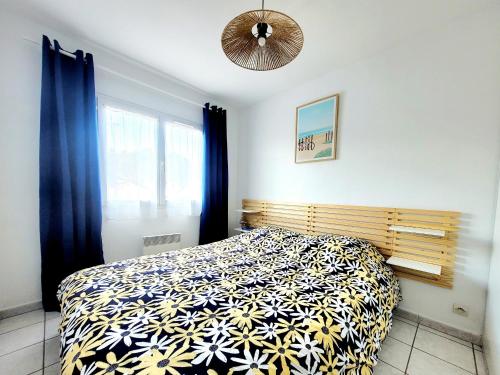 a bedroom with a bed with a black and white comforter at Canet en Roussillon - Maison T3 moderne pour 6 personnes - Terrasse spacieuse - Parking inclus - FR-1-794-147 in Canet-en-Roussillon