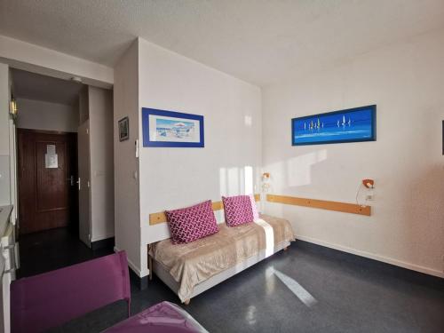 - une chambre avec un lit doté d'oreillers violets dans l'établissement Studio 4 personnes, face plage, parking, climatisation - Le Lavandou - FR-1-803-22, au Lavandou