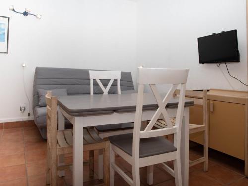 une table à manger avec deux chaises et une télévision dans l'établissement Studio cabine au Lavandou avec terrasse vue mer et parking privé, proche plage et commerces - FR-1-803-41, au Lavandou