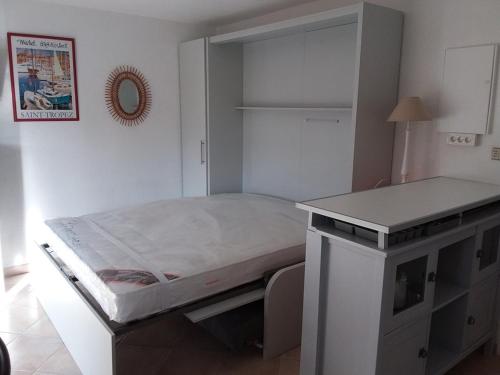 - un lit installé sur un bureau dans l'établissement Studio face mer avec clim, WiFi, parking privé, terrasse ensoleillée - FR-1-803-50, au Lavandou
