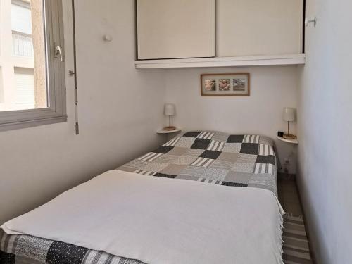 une petite chambre avec un lit dans une pièce dans l'établissement T2 avec piscine collective et parking à Bormes-les-Mimosas - FR-1-803-12, à Bormes-les-Mimosas