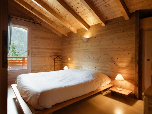 a bedroom with a bed in a wooden room at Chalet confortable 6 pers, 3 ch, à côté des pistes La Balme/Fernuy - FR-1-304-291 in La Clusaz