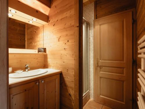 a bathroom with a sink and a wooden wall at Chalet confortable 6 pers, 3 ch, à côté des pistes La Balme/Fernuy - FR-1-304-291 in La Clusaz