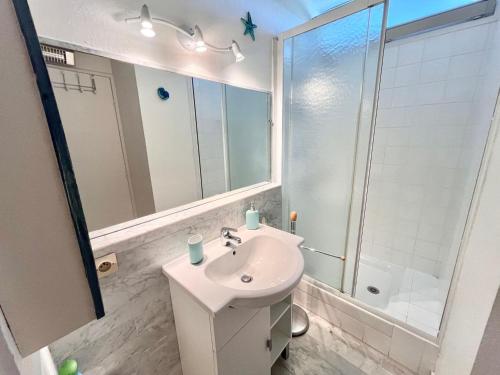 une salle de bain blanche avec un lavabo et une douche dans l'établissement Studio Lumineux avec Terrasse et Parking Privé, à 600m de la Plage - FR-1-716-76, à La Grande Motte