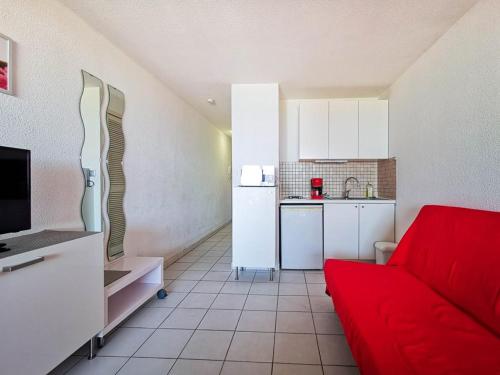 un salon avec un canapé rouge et une cuisine dans l'établissement Studio cabine face mer, 4 pers, parking privé, au Lavandou - FR-1-803-2, au Lavandou
