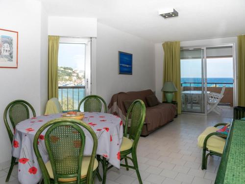 un salon avec une table et des chaises et un salon dans l'établissement Bel Appartement T2 pour 4 Personnes avec Terrasse, Parking et Climatisation - FR-1-803-47, au Lavandou