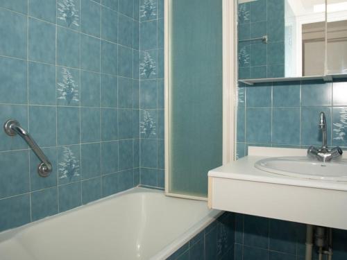 une salle de bain carrelée bleue avec un lavabo et une baignoire dans l'établissement Bel Appartement T2 pour 4 Personnes avec Terrasse, Parking et Climatisation - FR-1-803-47, au Lavandou