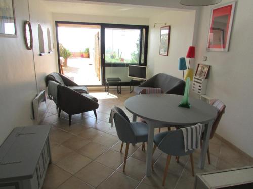 un salon avec une table et des chaises dans l'établissement Le Lavandou: Splendide T3 avec terrasse, climatisation, WiFi et parking - FR-1-803-3, au Lavandou