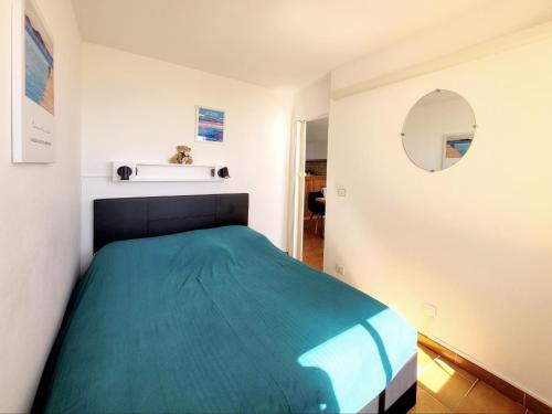 une chambre avec un lit avec une couverture bleue dans l'établissement Canet-en-Roussillon - T2 cosy - 4 pers - Parking privé - Clim - FR-1-794-154, à Canet