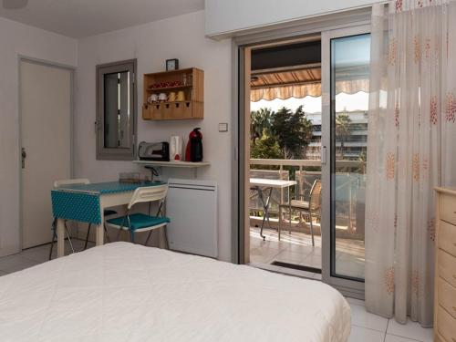 - une chambre avec un lit, une table et un balcon dans l'établissement Lavandou: Studio climatisé, terrasse, proche plage, 2 pers. - Pas d'animaux, sans parking - FR-1-803-43, au Lavandou