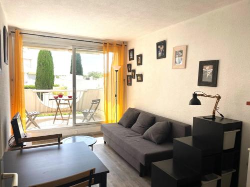 un salon avec un canapé et une table dans l'établissement Studio La Grande-Motte 2 pers. - Plage, Piscine, Terrasse, Parking Proche - FR-1-790-29, à La Grande Motte