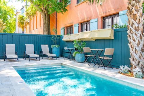 a swimming pool with chairs and a table next to a building at The Inn at 257 in Charleston