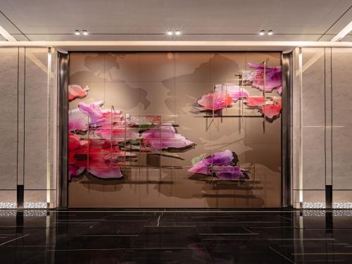 a display case with pink flowers in a room at Grand Mercure Shenzhen Guangming in Shenzhen
