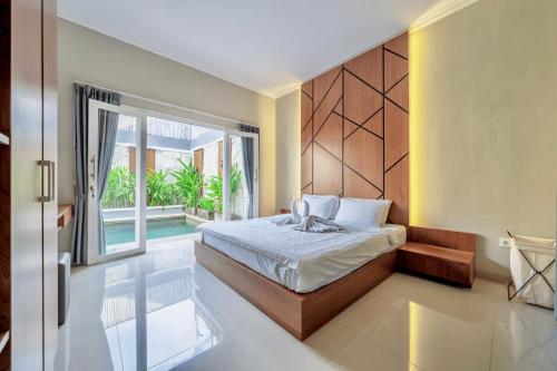 a bedroom with a bed and a large window at Modern 3BDR Villa - Between Seminyak & Canggu in Kerobokan