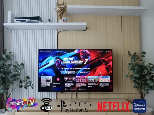a flat screen tv hanging on a wall at Auliya Homestay Melaka Seaview Pantai Puteri in Melaka