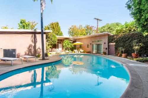 a swimming pool in front of a house at Bixby Beauty 50s Mod Long Beach in Long Beach