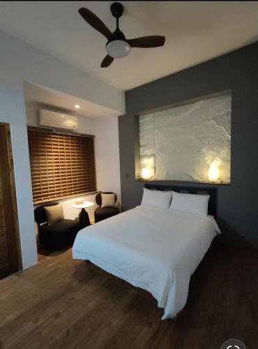 a bedroom with a large white bed and a couch at 小時公館城西 in Yuli