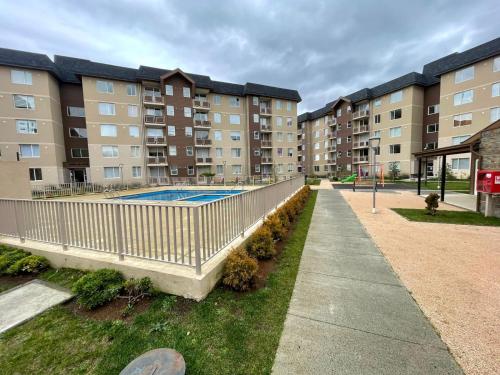 un complexe d'appartements avec une piscine en face d'un bâtiment dans l'établissement Departamento en Villarrica, à Villarrica
