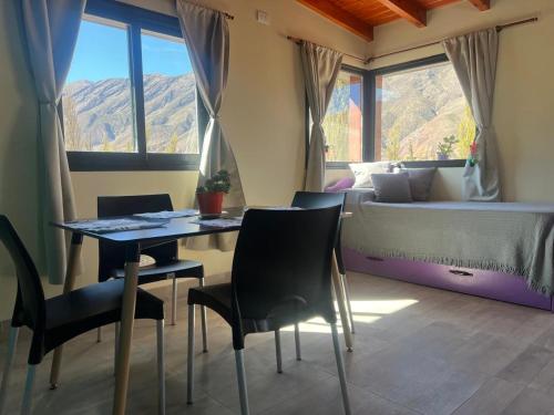 Un dormitorio con una cama y una mesa y sillas. en El Descanso del Wayra, en Tilcara