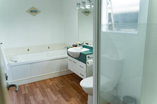 a bathroom with a toilet and a sink and a shower at Pacific Coast Motor Lodge in Whakatane