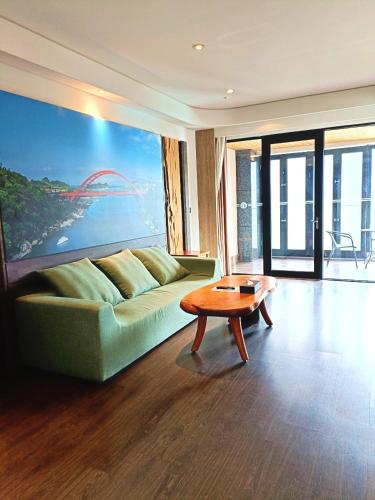 a living room with a green couch and a table at Chii Lih Resort in Luye