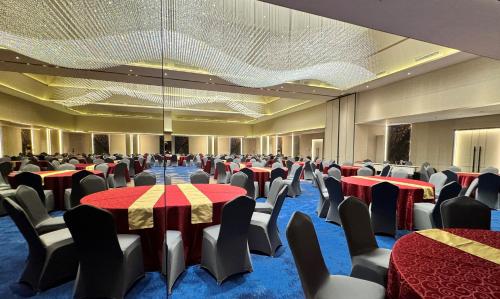 a banquet hall with red and yellow tables and chairs at Pentacity Hotel Balikpapan in Balikpapan