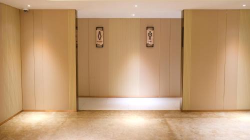 an empty room with a row of stalls in a building at Pentacity Hotel Balikpapan in Balikpapan
