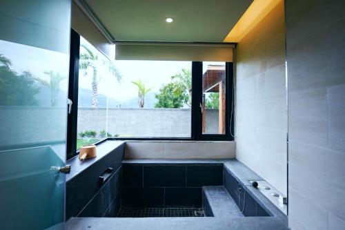 a bathroom with a bath tub with a window at Chii Lih Resort in Luye